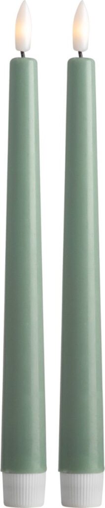Twee groene kaarsen met vlam